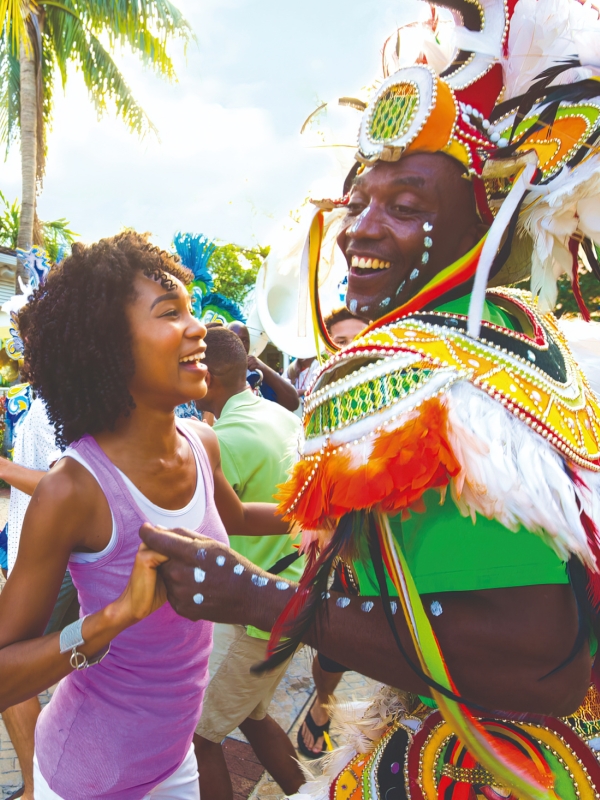A woman dancing with a Junkanoo dancer
