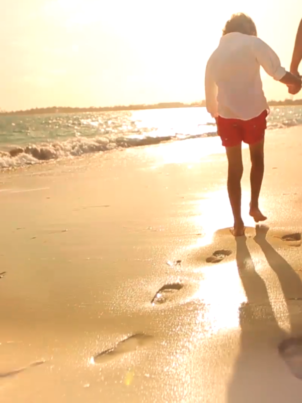 A man and his son walking on the beach in Nassau Paradise Island