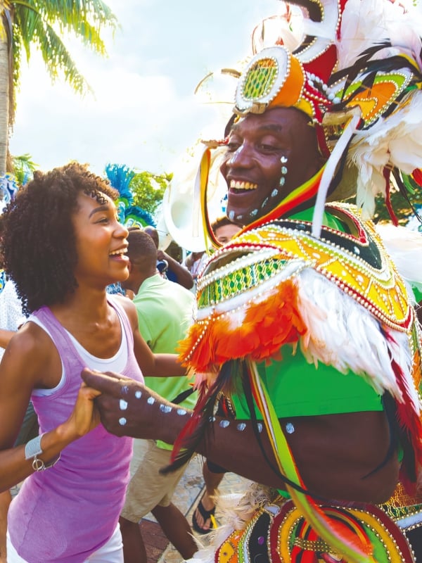 A woman dancing with a Junkanoo dancer