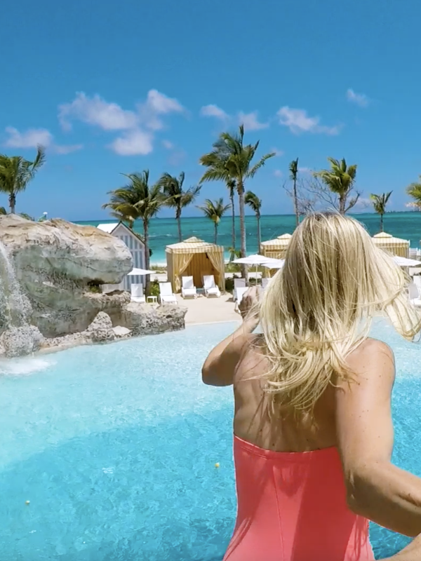A couple jumping into a pool in The Bahamas