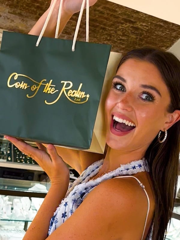 kelsey holding a coin of the realm shopping bag
