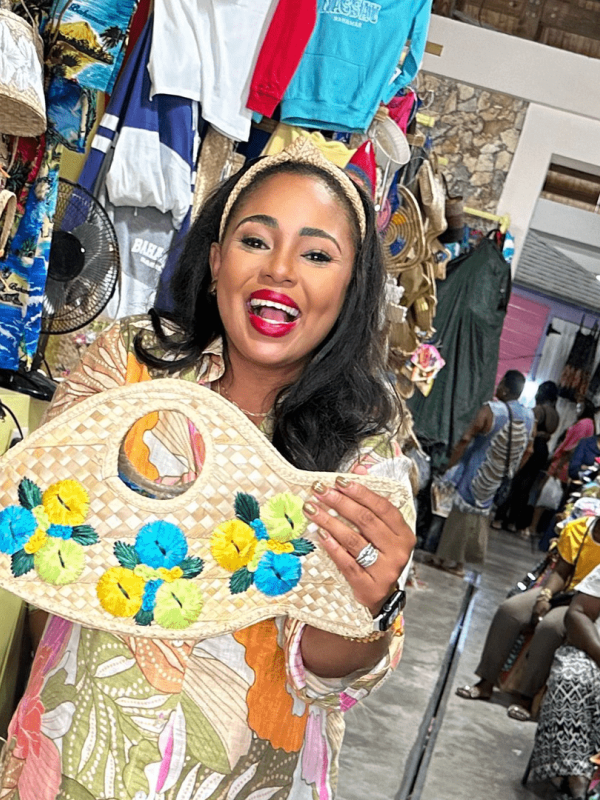 woman standing in a store pilled with items made out of straw