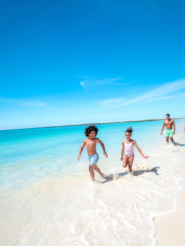 family running along the beach