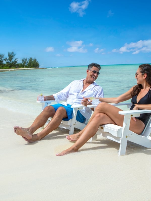 couple sitting in chairs on the beach