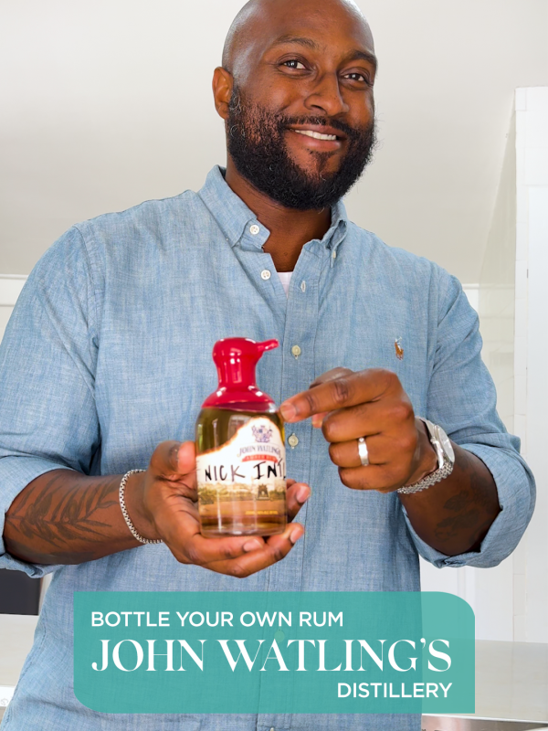 A man in a collared shirt holds a bottle of rum