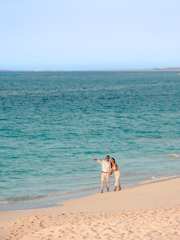 A couple walks along the beach in The Bahamas