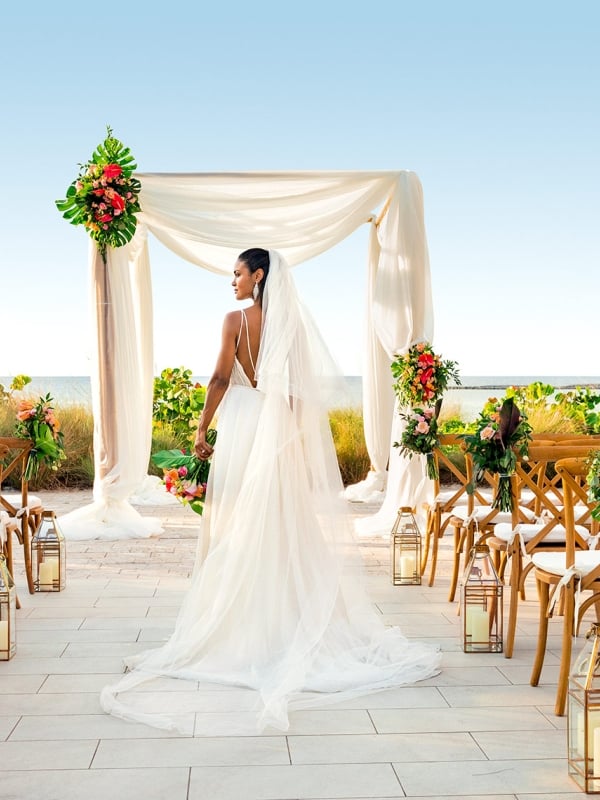 A bride walks down the aisle at her outdoor Bahamian wedding.