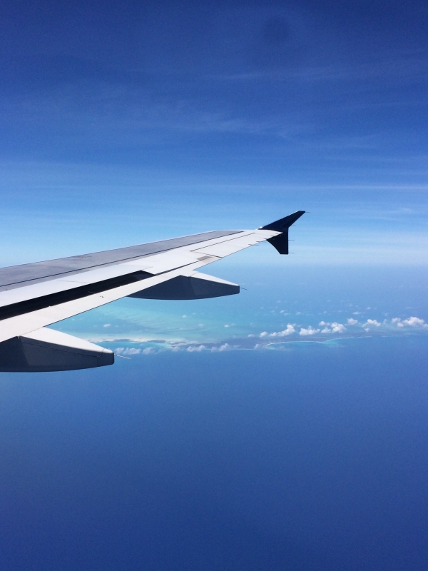 An airplane wing with the Bahamas islands in the background. 