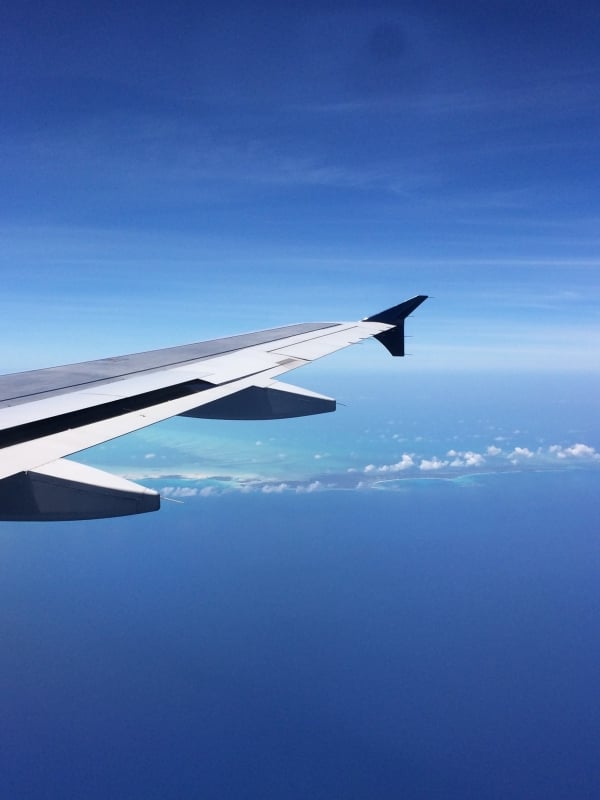 An airplane wing with the Bahamas islands in the background. 