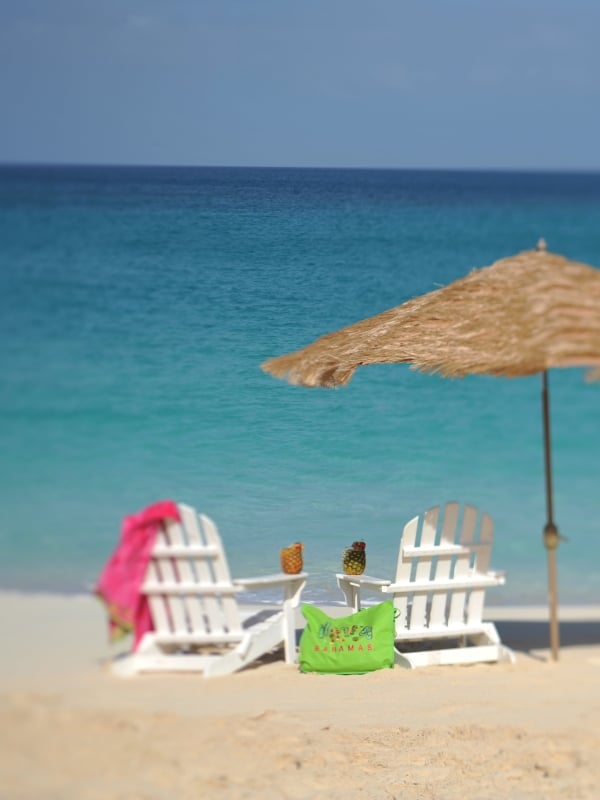 Two beach chairs on a white sand beach in The Bahamas