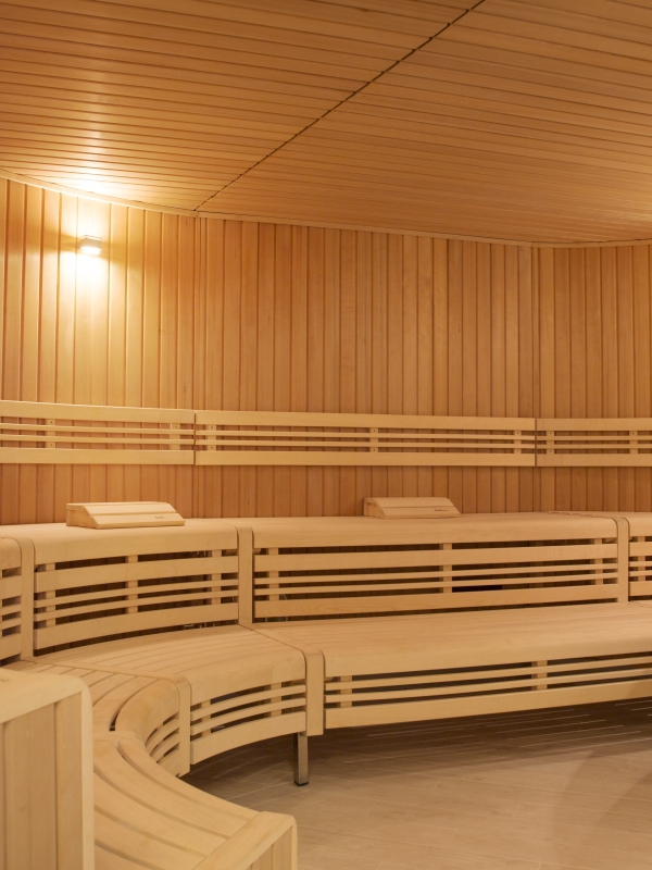 A round wooden sauna room with long benches