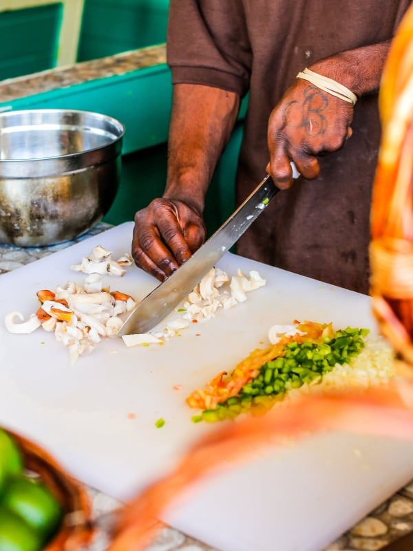 A chef chops fresh conch meat for conch salad in The Bahamas. 