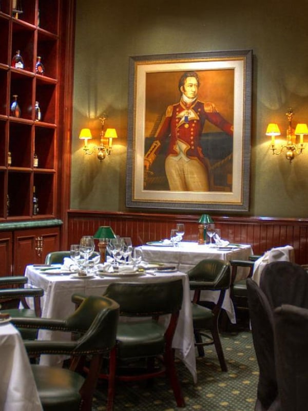 Dimly lit dining room with portrait in the background