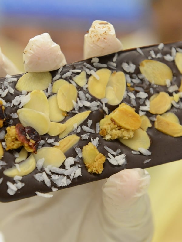 A handmade chocolate bar with coconut and almonds.