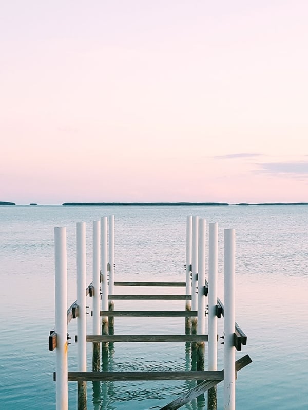 A dock going out over water during a sunset