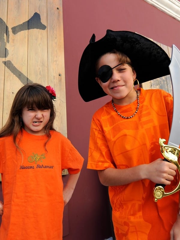A young girl and a young boy wearing pirate swag outside of the Pirate Museum.