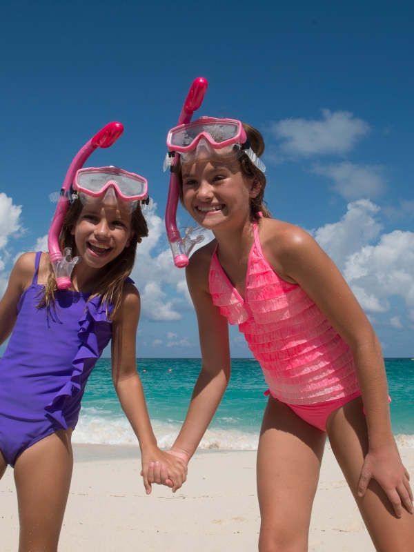 Two kids standing on the beach in snorkel gear