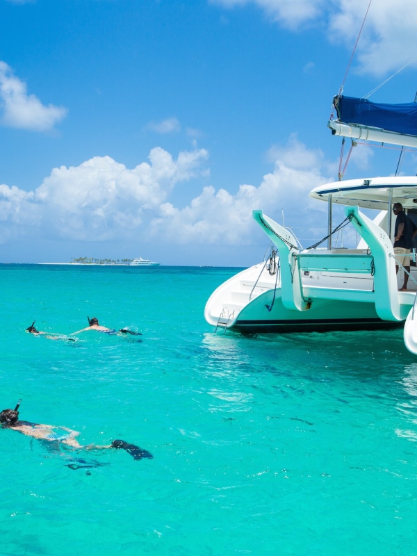 A family of four snorkel near a catamaran in Nassau Paradise Island.