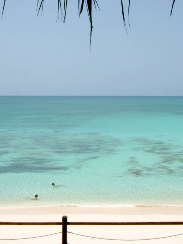 A serene beach scene with crystal-clear tropical water.