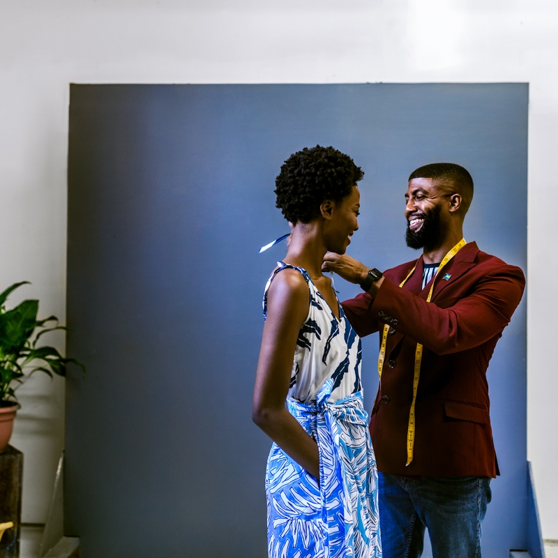 fashion designer adjusting a dress on a model
